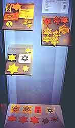Эти звезды нашивались на одежду евреев в годы Второй Мировой войны. Один из стендов Мемориального музея Яд ва-Шем.